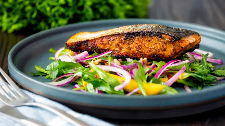 Pan fried crispy skinned jerk salmon fillet served with mango and rocket salad.