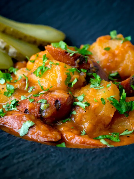 Close up Hungarian paprikas krumpli or paprika potatoes stew with pickles.