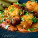 Close up Hungarian paprikas krumpli or paprika potatoes stew with pickles featuring a title overlay.