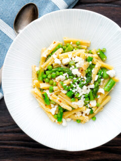 Overhead pea and asparagus pasta with casarecce, feta cheese and chilli flakes.