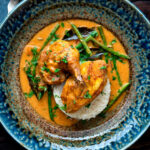 Overhead pheasant curry with coconut milk, green beans and rice featuring a title overlay.