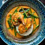 Overhead pheasant curry with coconut milk, green beans and rice featuring a title overlay.