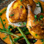 Close up pheasant curry with coconut milk, green beans and rice.