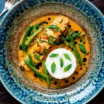 Overhead red Thai salmon curry with green beans and jasmine rice.