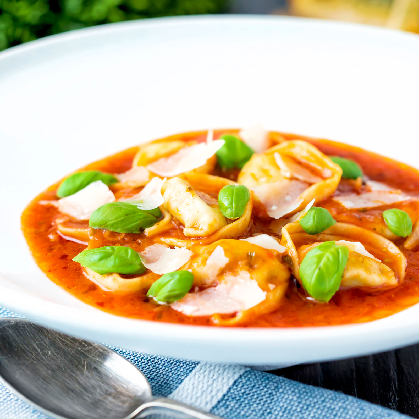 Quick and easy tortellini soup with tomato, fresh basil and parmesan shavings.
