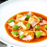 Store bought tortellini soup with tomato, fresh basil and parmesan shavings.