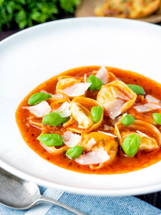 Store bought tortellini soup with tomato, fresh basil and parmesan shavings.