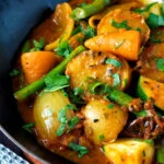 Close up vegan mixed vegetable karahi curry served in an iron kadai.