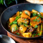 Vegan mixed vegetable karahi curry served in an iron kadai.