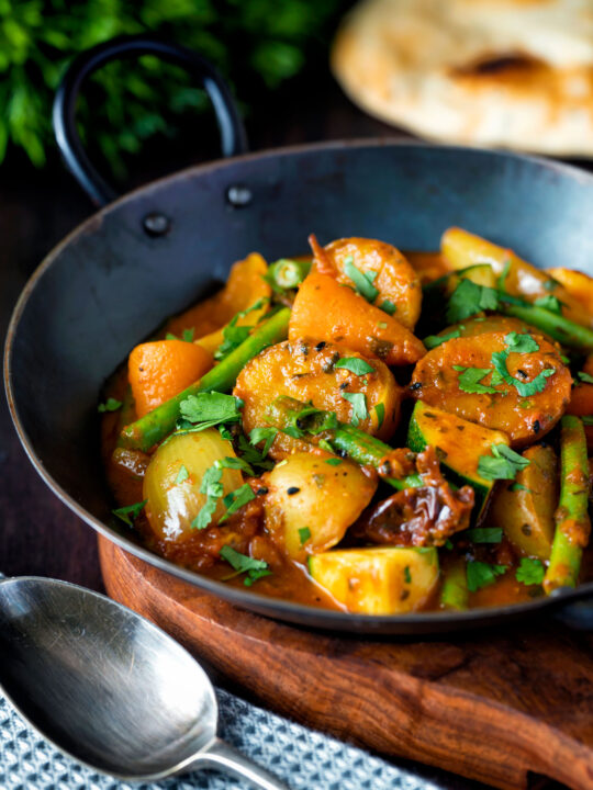 Vegan mixed vegetable karahi curry served in an iron kadai.