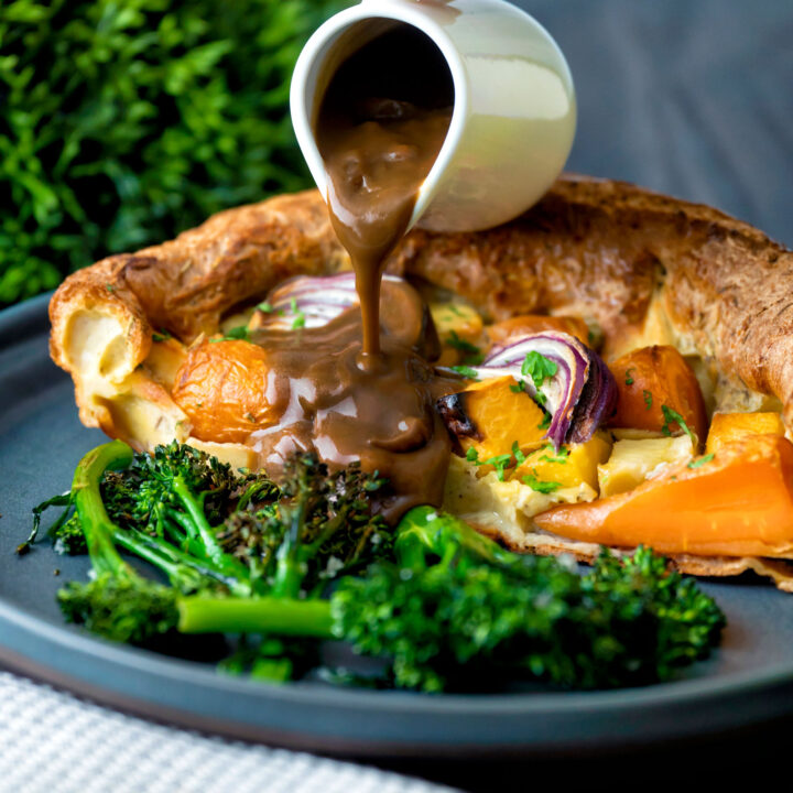 Vegetarian onion gravy poured over a roasted vegetable toad in the hole.