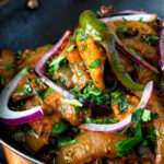 Close up achari chicken or chicken pickle served in a kadai.