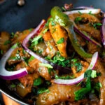 Close up achari chicken or chicken pickle served in a kadai.