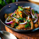 Achari chicken or chicken pickle served in a kadai with a chapati.