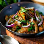 Achari chicken or chicken pickle served in a kadai with a chapati.