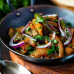 Achari chicken or chicken pickle served in a kadai with a chapati featuring a title overlay.
