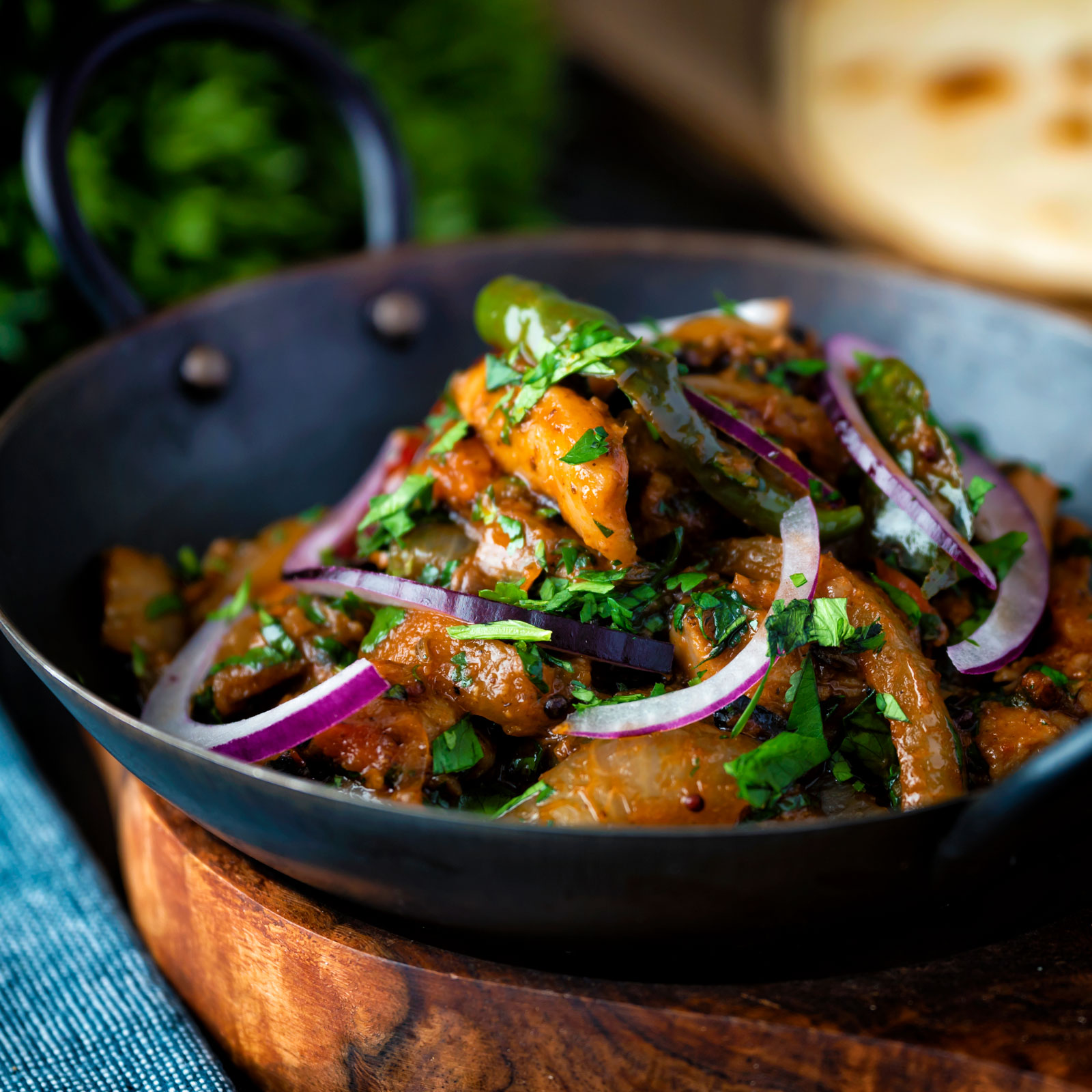 Achari chicken or murgh aka chicken pickle garnished with coriander and red onion.