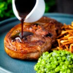 Port lamb sauce being poured over a pan fried Barnsley chop.