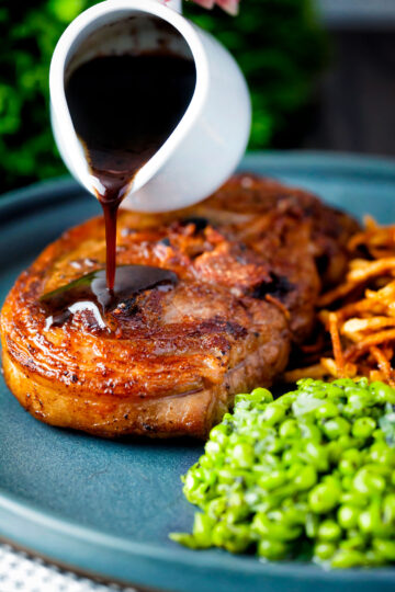 Port lamb sauce being poured over a pan fried Barnsley chop.