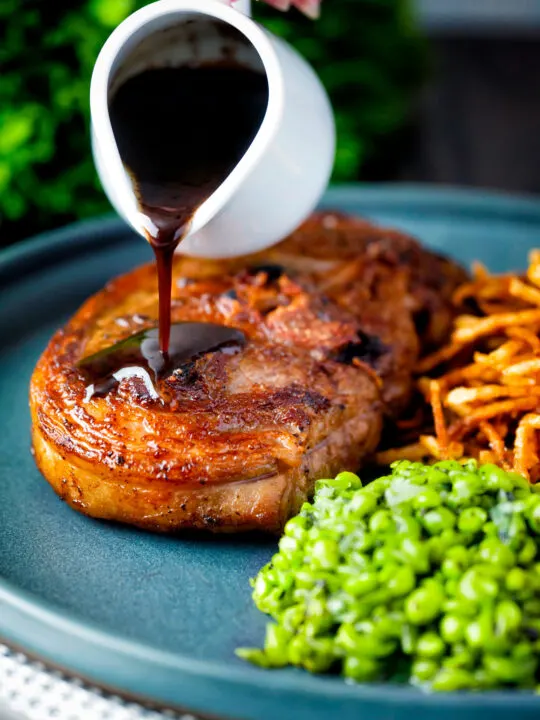 Port lamb sauce being poured over a pan fried Barnsley chop.