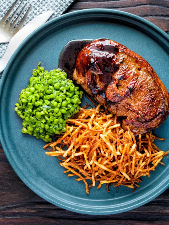 Over head pan fried Barnsley chop with port lamb sauce, straw potatoes and minted peas.