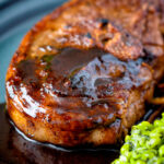 Close up pan fried Barnsley chop with port lamb sauce, and minted peas.