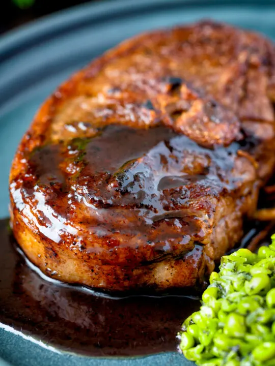 Close up pan fried Barnsley chop with port lamb sauce, and minted peas.