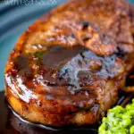 Close up pan fried Barnsley chop with port lamb sauce, and minted peas featuring a title overlay.