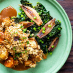 Overhead braised cavolo nero with peas and shallots served with veggie crumble.