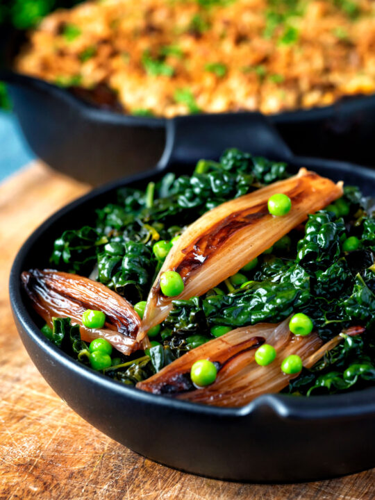 Braised cavolo nero with peas and shallots served with veggie crumble.