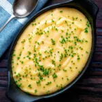 Overhead creamy cheesy polenta garnished with snipped chives.
