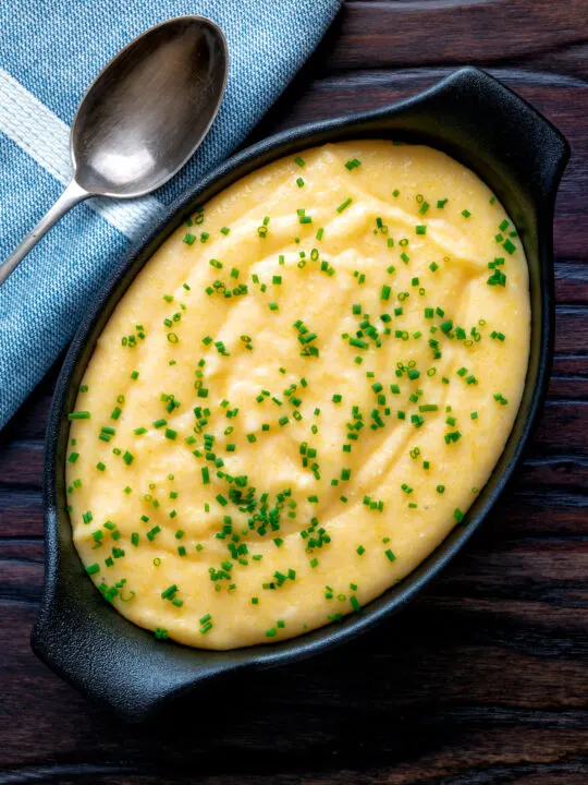 Overhead creamy cheesy polenta garnished with snipped chives.