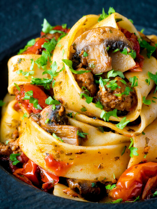 Close up chorizo pasta with pappardelle, tomatoes and mushrooms.