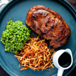 Crushed minted peas served with straw potatoes and a lamb Barnsley chop.