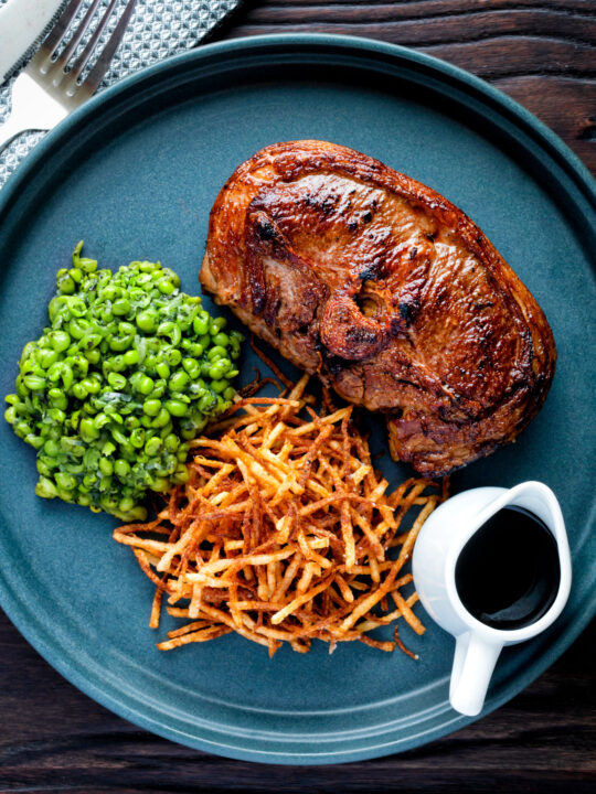 Crushed minted peas served with straw potatoes and a lamb Barnsley chop.