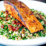 Pan fried harissa salmon fillet served with tabbouleh salad featuring a title overlay.