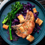 Overhead Instant Pot pork chops with red cabbage served with crispy crackling and broccoli.