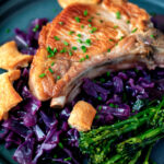 Close up Instant Pot pork chops with red cabbage, crispy crackling and broccoli.