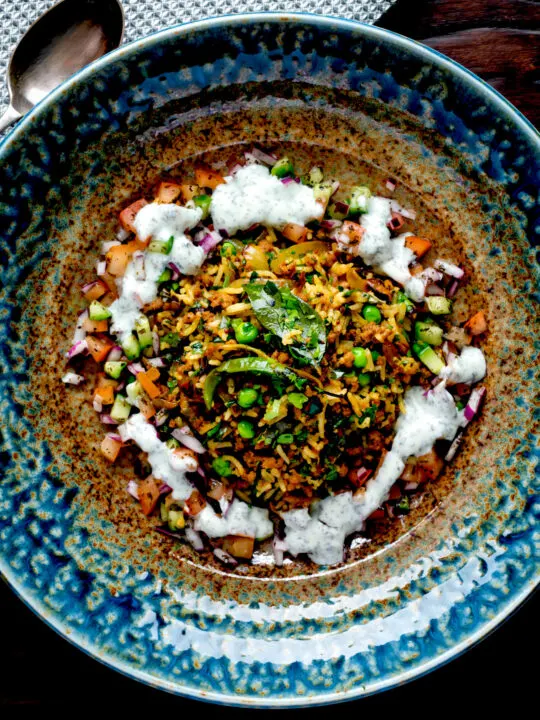 Overhead keema rice served with kachumber salad and mint raita.