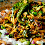 Close up keema rice served with kachumber salad and mint raita.