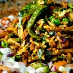 Close up keema rice served with kachumber salad and mint raita.