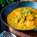 Matar paneer curry served in an iron kadai with fresh coriander.