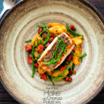 overhead pan fried hake with chorizo, new potatoes and samphire featuring a title overlay.