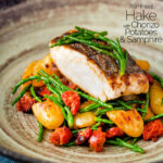 Pan fried hake with chorizo, new potatoes and samphire featuring a title overlay.