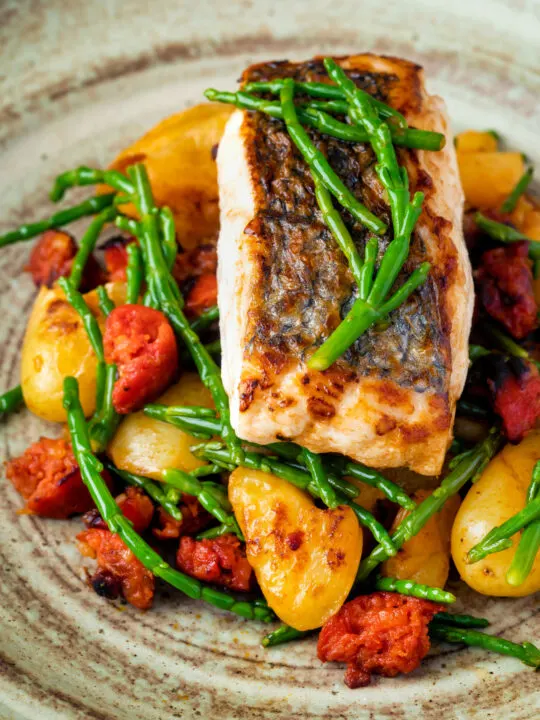 Close up pan fried hake with chorizo, new potatoes and samphire.