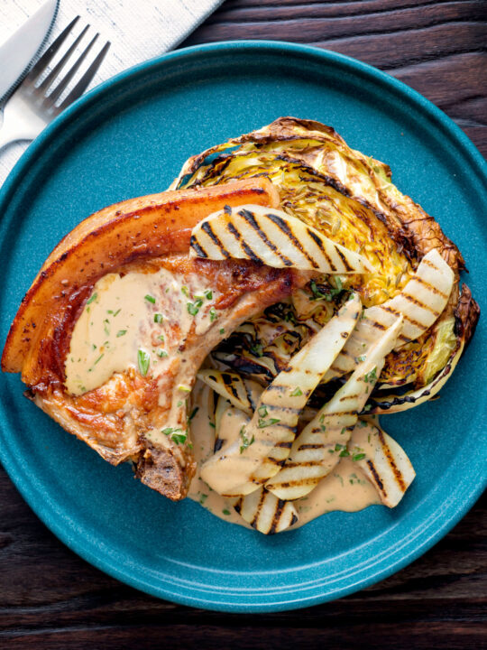 Overhead pork chops with pears and a cider tarragon sauce served with roasted cabbage.