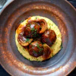 Overhead pork meatballs in a beer BBQ sauce served on cheesy polenta.