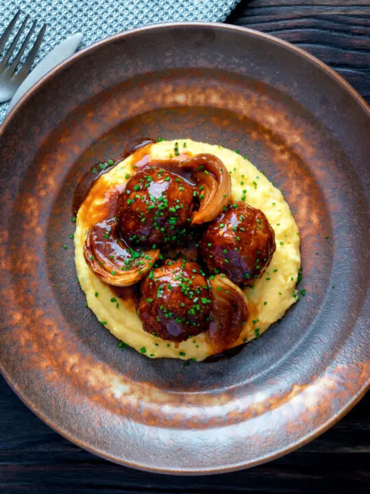 Overhead pork meatballs in a beer BBQ sauce served on cheesy polenta.