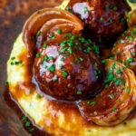 Close up pork meatballs in a beer BBQ sauce served on cheesy polenta.