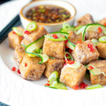 Salt and pepper tofu with a chilli soy dipping sauce and pickled cucumber featuring a title overlay.